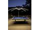 Night view of an outdoor patio featuring a pool table under an illuminated umbrella at 220 Belleview Blvd # 104, Belleair, FL 33756