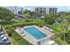 Aerial view of a refreshing community pool with plenty of lounge chairs and tables at 220 Belleview Blvd # 104, Belleair, FL 33756