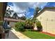 Well-manicured lawn and landscaping enhance this cozy backyard with walkway, trees and outdoor lighting at 2459 Bay Berry Dr, Clearwater, FL 33763
