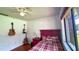 Cozy bedroom showcasing a red bed frame, guitars on the wall, and a view through a window to the outside at 2459 Bay Berry Dr, Clearwater, FL 33763