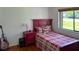 This cozy bedroom features a red bed frame with natural light, and hardwood floors at 2459 Bay Berry Dr, Clearwater, FL 33763