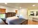 This main bedroom features neutral walls, a dark wood bed and ensuite bath with vanity at 2459 Bay Berry Dr, Clearwater, FL 33763
