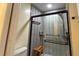 This shower includes a glass door, multiple grab bars, and a shower chair for accessibility at 2459 Bay Berry Dr, Clearwater, FL 33763