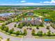 Aerial view of a community clubhouse featuring a pool, tennis courts, and lush landscaping at 2495 Oakwood Preserve Dr, Wesley Chapel, FL 33543