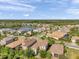 Aerial view of homes in a suburban neighborhood featuring a lake and lush landscaping at 2495 Oakwood Preserve Dr, Wesley Chapel, FL 33543
