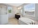 Bright bathroom featuring a bathtub, shower, and double windows letting in tons of natural light at 2495 Oakwood Preserve Dr, Wesley Chapel, FL 33543