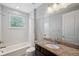 Bright bathroom with granite countertop vanity, shower-tub combo, and ample natural light creating a refreshing space at 2495 Oakwood Preserve Dr, Wesley Chapel, FL 33543