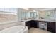 Spacious bathroom featuring double sinks, vanity with stool, and tub with a large window offering natural light at 2495 Oakwood Preserve Dr, Wesley Chapel, FL 33543