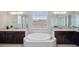 Luxurious bathroom featuring double vanities and a centrally located soaking tub for ultimate relaxation at 2495 Oakwood Preserve Dr, Wesley Chapel, FL 33543