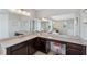 Bright bathroom featuring double sinks, spacious vanity with seated makeup area, and expansive mirrors at 2495 Oakwood Preserve Dr, Wesley Chapel, FL 33543