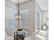 Charming dining area with glass-topped table, modern chandelier, bright windows, and access to the outdoors at 2495 Oakwood Preserve Dr, Wesley Chapel, FL 33543