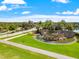 Scenic aerial view of a community entrance featuring a pond, water feature, and lush landscaping at 2495 Oakwood Preserve Dr, Wesley Chapel, FL 33543