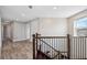Well-lit hallway with wood flooring and a staircase leading to another floor, offering seamless navigation throughout the home at 2495 Oakwood Preserve Dr, Wesley Chapel, FL 33543
