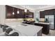 Modern kitchen featuring dark cabinetry, stainless steel appliances, and a large quartz countertop island with seating at 2495 Oakwood Preserve Dr, Wesley Chapel, FL 33543