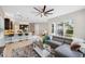 Open-concept living room boasts modern furnishings, a large fan, tile flooring, and a seamless transition to the kitchen at 2495 Oakwood Preserve Dr, Wesley Chapel, FL 33543