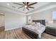 Beautiful main bedroom with wood floors, a tray ceiling, and a large window offering scenic views of the outdoors at 2495 Oakwood Preserve Dr, Wesley Chapel, FL 33543