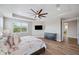 Spacious main bedroom featuring a tray ceiling, ceiling fan, and wood flooring with a large window for natural light at 2495 Oakwood Preserve Dr, Wesley Chapel, FL 33543
