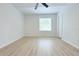 Spacious bedroom featuring light wood floors, white walls, ceiling fan, and a window for natural light at 4332 Har Paul Cir, Tampa, FL 33614