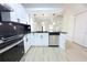 Stylish kitchen featuring sleek black countertops, stainless steel appliances, and a view into the spacious living area at 4332 Har Paul Cir, Tampa, FL 33614