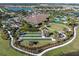 Stunning aerial view of community clubhouse, pool, bocce ball courts, and gathering area near a scenic lake at 4506 Stickley Ct, Palmetto, FL 34221