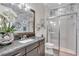 Well-lit bathroom with a granite countertop vanity, framed mirror, and glass enclosed shower at 4506 Stickley Ct, Palmetto, FL 34221