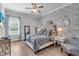 Stylish bedroom with wood floors, patterned wallpaper, a tufted headboard and designer furnishings at 4506 Stickley Ct, Palmetto, FL 34221