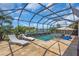 Relaxing screened pool area with chaise lounges, chairs, umbrella, and scenic lake views at 4506 Stickley Ct, Palmetto, FL 34221