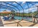 Inviting pool and spa in screened lanai with seating and an umbrella, set against a lake backdrop at 4506 Stickley Ct, Palmetto, FL 34221
