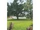 Lush green community area showcasing mature trees and a fenced community pool in the background at 4550 Overlook Ne Dr # 156, St Petersburg, FL 33703