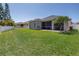 Large, fenced backyard with lush green grass and a screened-in lanai at 511 York Dale Dr, Ruskin, FL 33570
