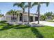 Charming single-story home featuring a well-manicured lawn, palm trees and a three car garage at 511 York Dale Dr, Ruskin, FL 33570