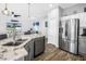 Well-lit kitchen showcasing a granite island with sink, dishwasher, and stainless steel refrigerator at 511 York Dale Dr, Ruskin, FL 33570