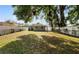 Large backyard featuring a home exterior, secure white fence, and an abundance of mature shade trees at 5111 N 30Th St, Tampa, FL 33610