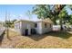 Cozy home exterior featuring a small backyard with a chain-link fence and ample trees on a sunny day at 5111 N 30Th St, Tampa, FL 33610