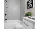 Modern bathroom with gray tile, white tub, and upgraded black matte fixtures at 5111 N 30Th St, Tampa, FL 33610