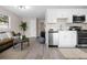 Open-concept kitchen featuring modern appliances, white cabinetry, and a seamless transition to the living room at 5111 N 30Th St, Tampa, FL 33610