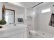 Bright bathroom features a white vanity, framed mirror, and shower with white tiles at 5207 Moeller Ave, Sarasota, FL 34233