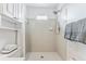 Bright white tiled shower with chrome shower head and small window for natural light at 5207 Moeller Ave, Sarasota, FL 34233
