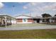 View of the recreation hall from the shuffleboard court with benches at 6000 20Th N St # 138, St Petersburg, FL 33714