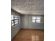 Bedroom featuring laminated floors, two windows and light-colored walls, creating a serene retreat at 6012 Frond Way, Apollo Beach, FL 33572