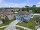 An aerial view of a two-story home with a manicured lawn, spacious driveway, and mature landscaping at 662 Petal Mist Ln, Brooksville, FL 34604