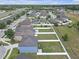 An aerial shot of a blue home with a fenced backyard and a community view with other homes nearby at 662 Petal Mist Ln, Brooksville, FL 34604
