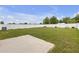 Spacious backyard with lush green grass, a white fence and play set at 662 Petal Mist Ln, Brooksville, FL 34604