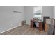 Bedroom with wood-look floors, neutral gray walls, a window and a desk at 662 Petal Mist Ln, Brooksville, FL 34604