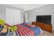 Bedroom featuring a bed with colorful striped bedding and closet with white doors at 662 Petal Mist Ln, Brooksville, FL 34604