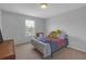 Cozy bedroom with a window and carpet flooring, featuring a playful bed with colorful bedding at 662 Petal Mist Ln, Brooksville, FL 34604