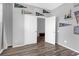 Bedroom with wood-look floors, gray walls and decor, and an open closet with white doors at 662 Petal Mist Ln, Brooksville, FL 34604