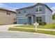 Charming two-story home with a well-manicured lawn, two-car garage, and blue shutters at 662 Petal Mist Ln, Brooksville, FL 34604