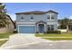 Charming two-story home boasts a well-manicured lawn, beautiful blue shutters and a matching two car garage door at 662 Petal Mist Ln, Brooksville, FL 34604
