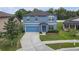 Beautiful two-story home with a well-manicured lawn, blue shutters, and a spacious driveway at 662 Petal Mist Ln, Brooksville, FL 34604